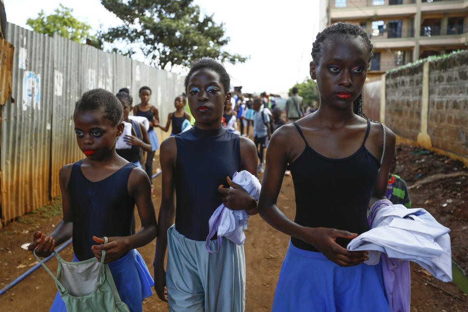 Young dancers walk to participate in a Christmas ballet event, in Kibera, one of the busiest neighborhoods of Kenya's capital, Nairobi, Friday, Dec. 15, 2023. The ballet project is run by Project Elimu, a community-driven nonprofit that offers after-school arts education and a safe space to children in Kibera. (AP Photo/Brian Inganga)