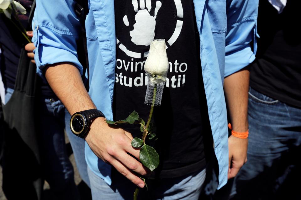 A student holds a rose during a protest in Caracas, Venezuela, Friday, Feb. 14, 2014. Students are protesting the Wednesday killings of two university students who were shot in different incidents following an anti-government protest demanding the release of student protesters who had been arrested in various parts of the country. (AP Photo/Fernando Llano)