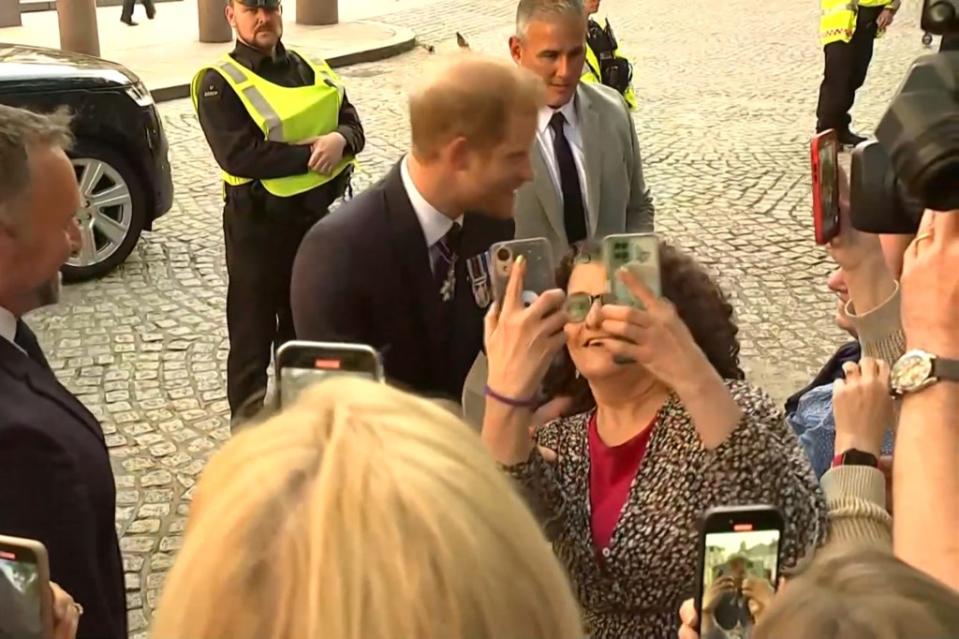 Prince Harry (center) continued greeting people after an awkward encounter with an overbearing fan. Reuters