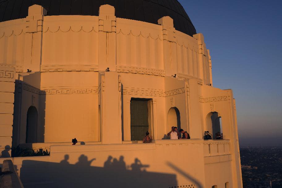 This July 12, 2016 photo shows visitors at the Griffith Observatory in Los Angeles. Fans of movies nominated for Oscars this year will be pleased to know that they can visit many real places in homage to their favorite films, from a diner in Miami where part of "Moonlight" was shot to a pier in Los Angeles used in "La La Land" and a house in Pittsburgh used in "Fences." (AP Photo/Richard Vogel)