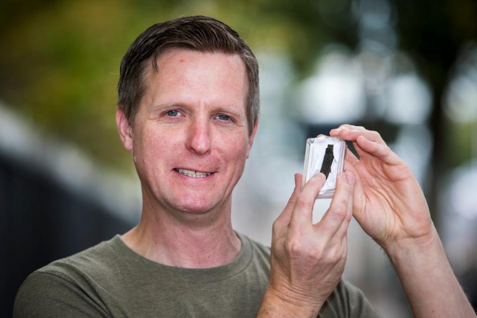 Treasure hunter Michael Thompson holding a folded Viking age silver arm-ring he found in the Ballinderry area of Co Antrim using a metal detector (PA) (PA Archive)