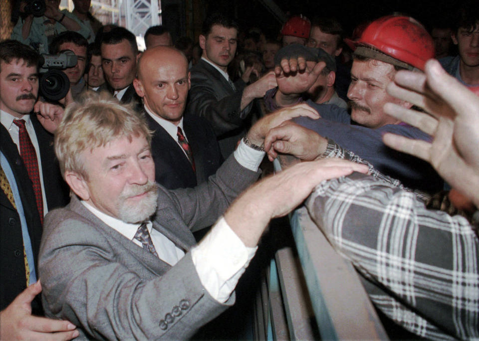 In this file photo from April 30 1998, Poland’s Cold War spy, Ryszard Kuklinski greets steel mill workers in Nowa Huta, southern Poland. From behind the Iron Curtain, Kuklinski passed some 35,000 pages of Warsaw Pact secrets to the CIA, including the communist government's plan to impose martial law in 1981 and launch a brutal crackdown on the pro-democracy Solidarity movement. He was spirited out of Poland with his wife and two sons shortly before the Dec. 13, 1981 military crackdown, and the family lived in hiding in the U.S. Poland’s military court sentenced him to death for treason and desertion. The charges were lifted in 1998 and Kuklinski came on a visit.(AP Photo/Czarek Sokolowski)