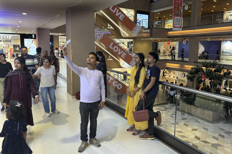 People take selfies in a shopping mall, in Patna, in the Indian state of Bihar, on May 13, 2024. (AP Photo/Manish Swarup)