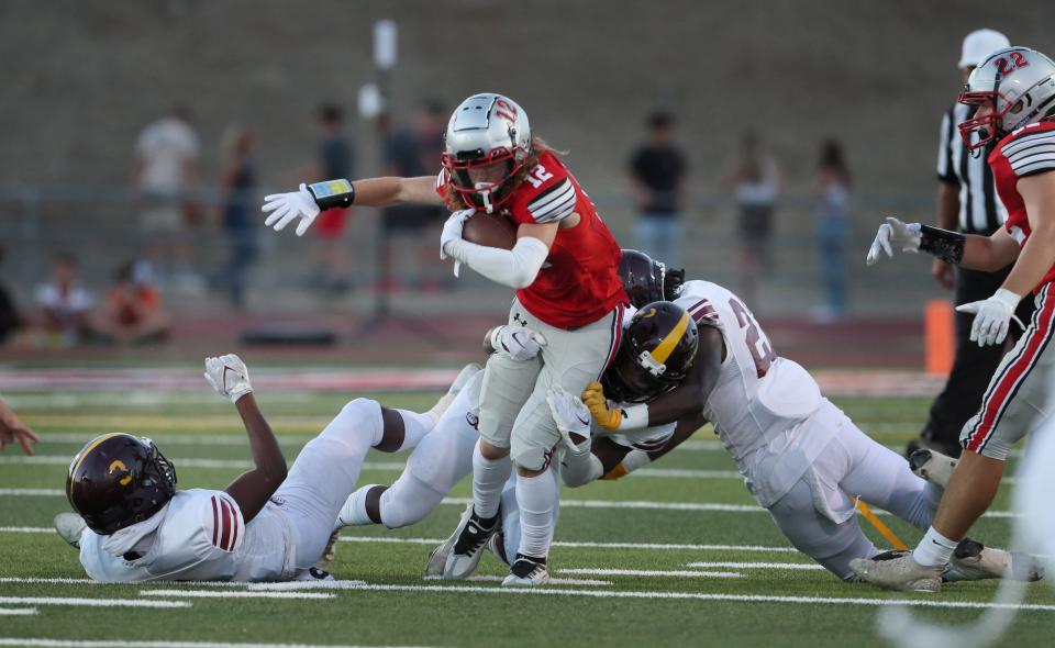 Foothill's Chris Hall tries to break away from Edison defense players in the first quarter of the game on Friday night, Aug. 26, 2022 in Palo Cedro, California.