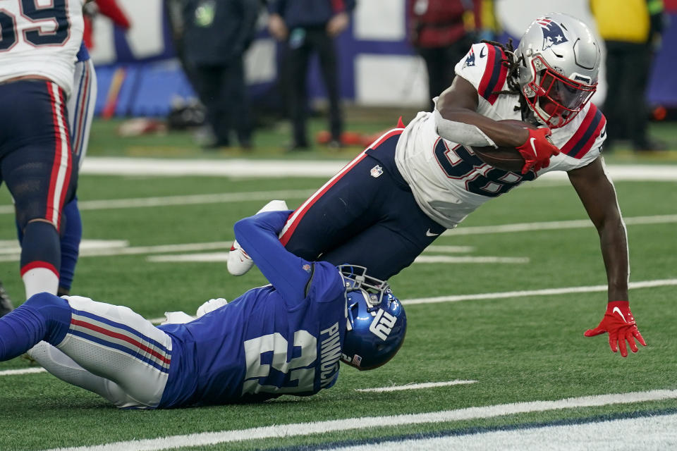 RETRANSMISSION TO CORRECT PLAYER AND TEAM - New England Patriots running back Rhamondre Stevenson (38) crosses the goal line for a touchdown against New York Giants safety Jason Pinnock (27) during the third quarter of an NFL football game, Sunday, Nov. 26, 2023, in East Rutherford, N.J. (AP Photo/Seth Wenig)