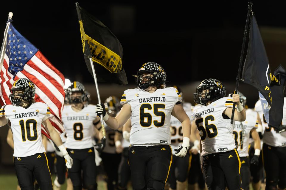 The Garfield G-Men take the field prior to an OHSAA regional semifinal playoff game against Perry High School Friday, Nov. 10, 2023 in Maple Heights, OH.