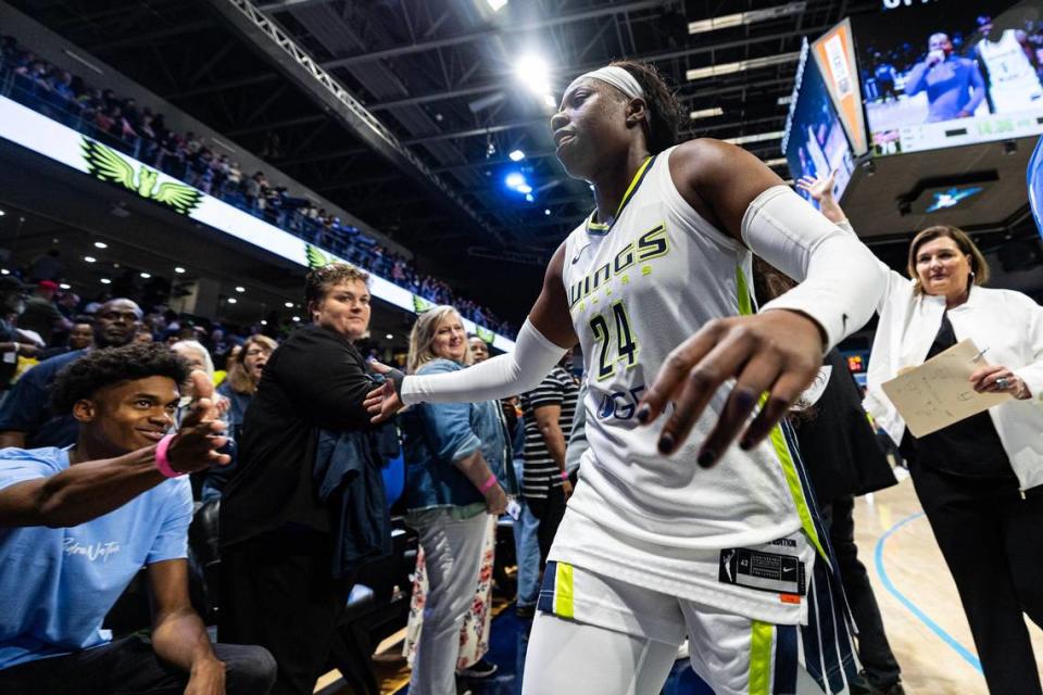 Dallas Wings guard Arike Ogunbawale (24) high fives a fan while heading back to the locker room after making the game-winning, three-point shot in the fourth quarter of a WNBA preseason game between the Dallas Wings and Indiana Fever at College Park Center in Arlington on Friday, May 3, 2024.