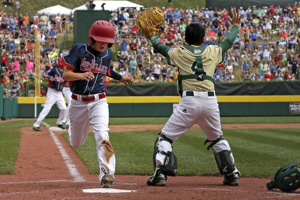 Endwell, N.Y.'s Jude Abbadessa, left, scores past South Korea's Junseo Cho on a single by New York's Conner Rush in the fourth of the Little League World Series Championship baseball game in South Williamsport, Pa., Sunday, Aug. 28, 2016. (AP Photo/Gene J. Puskar)