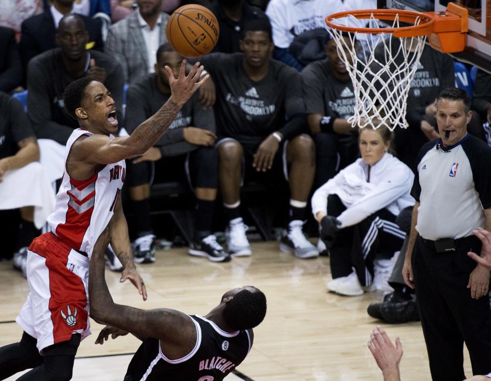 Toronto Raptors guard DeMar DeRozan, left, drives over Brooklyn Nets forward Andray Blatche to score during the second half of Game 2 in an NBA basketball first-round playoff series, Tuesday, April 22, 2014, in Toronto. (AP Photo/The Canadian Press, Nathan Denette)