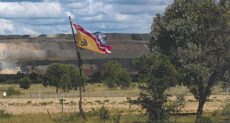 Another image shows a flag representing Indigenous people continuing traditional practices near the mine. 