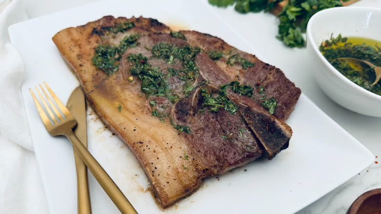 pork steak with chimichurri on white plate