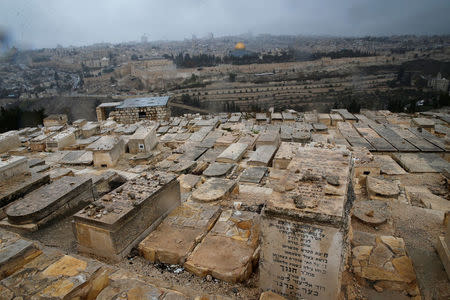A Jewish cemetery on the Mount of Olives is seen in the foreground as the Dome of the Rock, located in Jerusalem's Old City on the compound known to Muslims as Noble Sanctuary and to Jews as Temple Mount, is seen in the background December 6, 2017. REUTERS/Ammar Awad