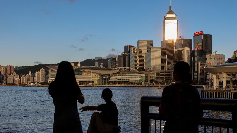 Tourists look out over Hong Kong's Victoria Harbour and the city skyline on July 10, 2023. - Tyrone Siu/Reuters/File