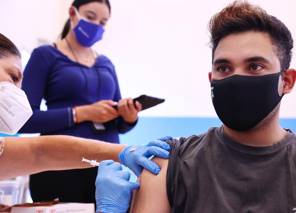 Nurse administers COVID-19 vaccine to a community health worker