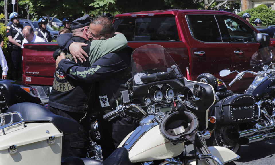 Members of the Jarheads Motorcycle Club embrace prior to the funeral for Michael Ferazzi at St. Peter's Catholic Church in Plymouth, Mass., Friday, June 28, 2019. Ferazzi, a motorcyclist and retired police officer, was killed in a fiery crash that claimed the lives of seven people riding with the Jarheads Motorcycle Club in New Hampshire. (AP Photo/Charles Krupa)