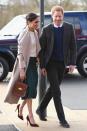 <p>For a surprise visit to Belfast, Markle chose a dusty pink coat over a white shirt and vibrant green skirt. She paired the look with a top-handled bag and maroon stilettos.</p>