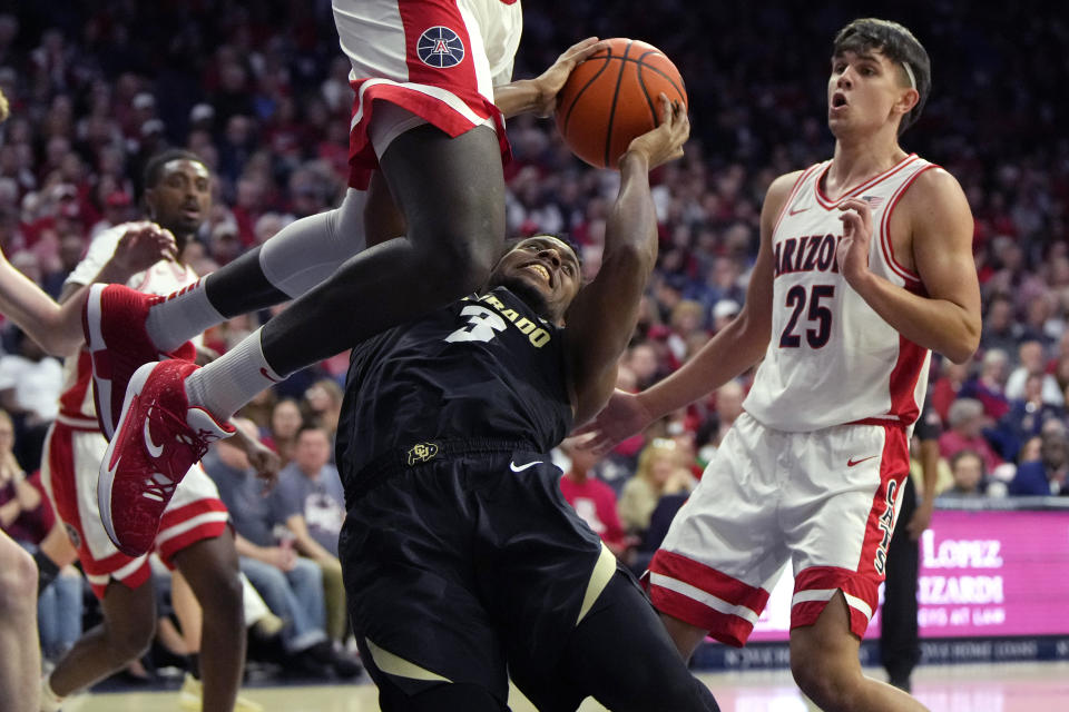 Colorado guard Jalen Gabbidon (3) drives between Arizona center Oumar Ballo and Arizona guard Kerr Kriisa (25) during the first half of an NCAA college basketball game, Saturday, Feb. 18, 2023, in Tucson, Ariz. (AP Photo/Rick Scuteri)