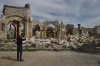 A man photographs the Church of Saint Simeon 30 kilometers (19 miles) northwest of Aleppo, Syra, Wednesday, March 8, 2023. The Byzantine-era church suffered destruction during the war and was further damaged in the February 2023 earthquake, which hit Turkey and Syria. (AP Photo/Omar Albam)