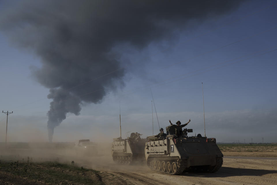 FILE - Israeli soldiers move on armored personnel carriers (APC) near the Israeli-Gaza border as smoke rises to the sky in the Gaza Strip, seen from southern Israel, on Jan. 21, 2024. An AP analysis of Gaza Health Ministry data finds the proportion of Palestinian women and children being killed in the Israel-Hamas war appears to have declined sharply. Israel faces heavy international criticism over unprecedented levels of civilian casualties in Gaza. (AP Photo/Leo Correa, File)