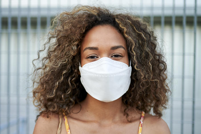 Portrait of young woman with antiviral mask outdoors