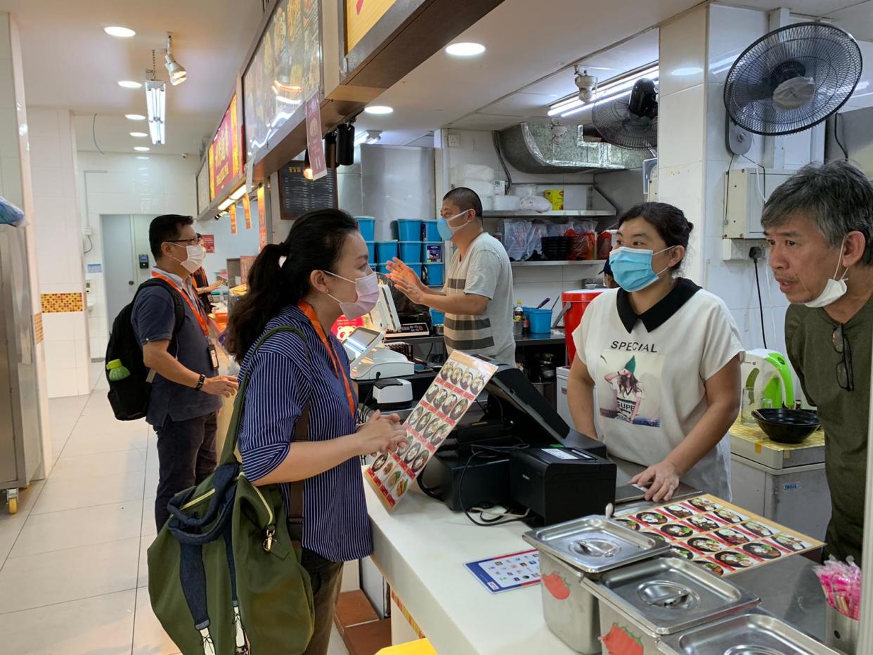 Safe Distancing and SG Clean ambassadors speaking to hawkers during the elevated safe distancing period to curb the spread of COVID-19. (PHOTO: Facebook/Masagos Zulkifli)