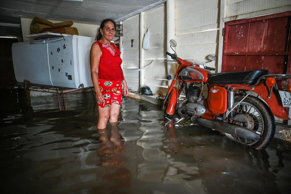 <p>woman is seen next to her belongings in their flooded house after the passage of Hurricane Helene in Guanimar, Artemisa province, Cuba</p> (AFP via Getty Images)