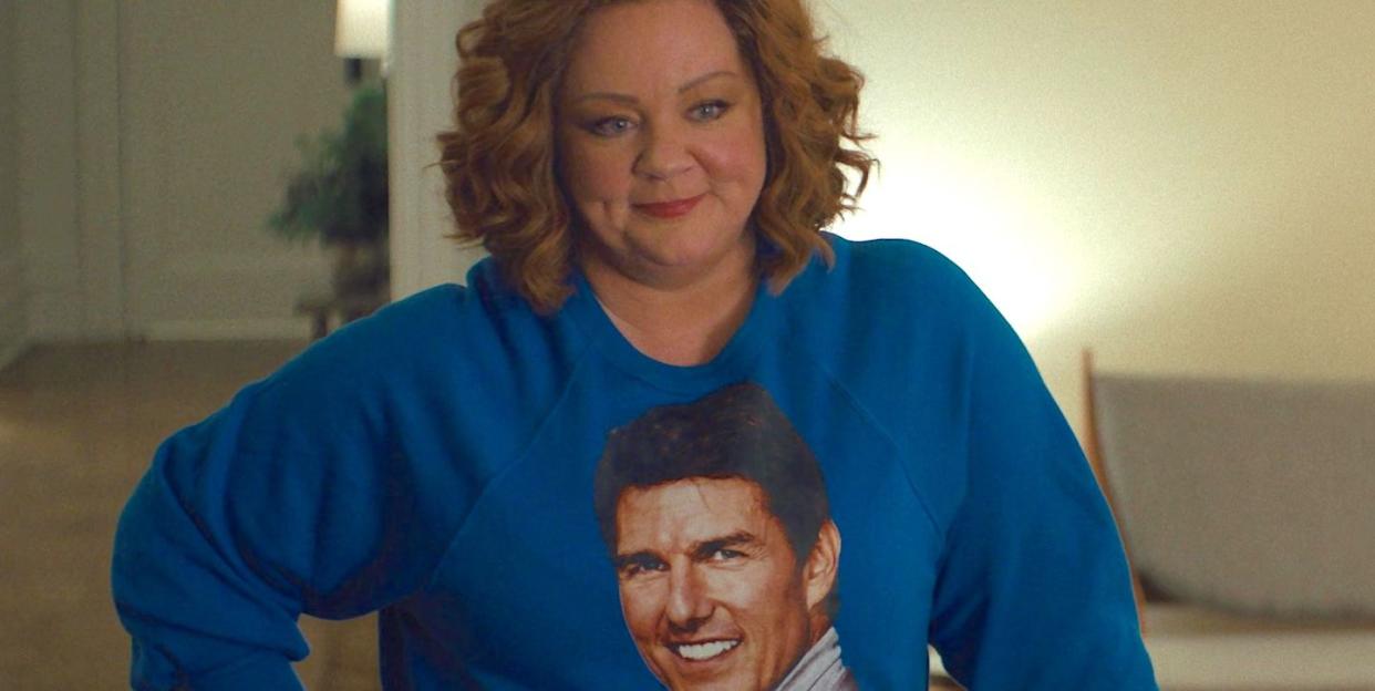 melissa mccarthy in genie, a woman smiles as she wears a blue jumper with tom cruise's face on it