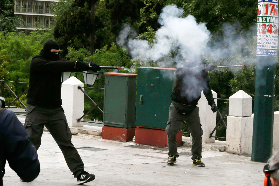 <p>Protesters aim with a flare gun to the riot police during clashes at a nationwide general strike demonstration, in Athens, Wednesday, May 17, 2017. Greek workers walked off the job across the country Wednesday for an anti-austerity general strike that was disrupting public and private sector services across the country. (AP Photo/Thanassis Stavrakis) </p>