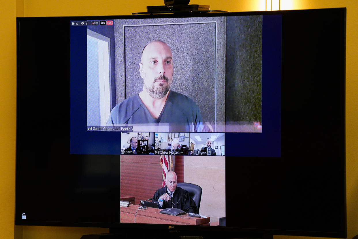 Sean M. Higgins, top, the alleged drunken driver charged with killing NHL hockey player Johnny Gaudreau and his brother Matthew as they bicycled on a rural road, appears before Judge Michael Silvanio, bottom, for his hearing via video from jail, Friday, Sept. 13, 2024, in Woodbury, N.J. (AP Photo/Derik Hamilton)