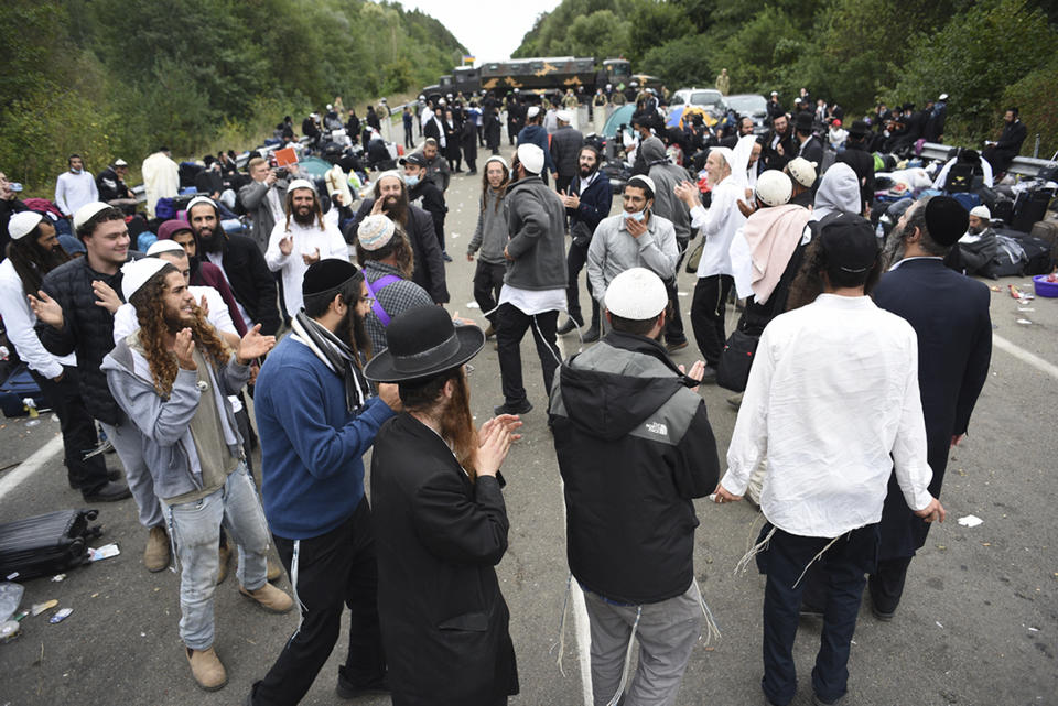 Jewish pilgrims dance as they gather on the Belarus-Ukraine border, in Belarus, Tuesday, Sept. 15, 2020. About 700 Jewish pilgrims are stuck on Belarus' border due to coroavirus restrictions that bar them from entering Ukraine. Thousands of pilgrims visit the city each September for Rosh Hashana, the Jewish new year. However, Ukraine closed its borders in late August amid a surge in COVID-19 infections. (TUT.by via AP)