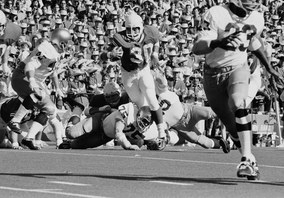 FILE - Steve Worster (30), University of Texas fullback, breaks away from Notre Dame's Greg Marx (75), as he rips off three yards in the first quarter of the Cotton Bowl in Dallas, Jan. 1, 1971. Worster, the powerful fullback in a bruising wishbone offense that led Texas to the undisputed national championship in 1969 and the brink of another a year later, died Aug. 13, 2022, the school announced. He was 73. (AP Photo/File)
