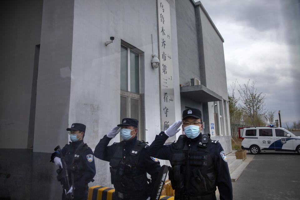 Police officers salute at the outer entrance of the Urumqi No. 3 Detention Center in Dabancheng in western China's Xinjiang Uyghur Autonomous Region on April 23, 2021. (AP Photo/Mark Schiefelbein)