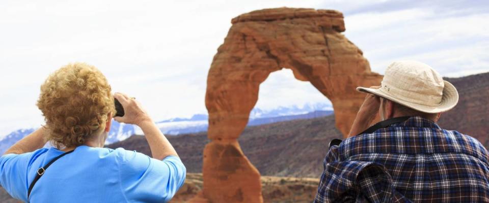 Seniors couple enjoying the beauty of Delicate Arch, Utah, USA