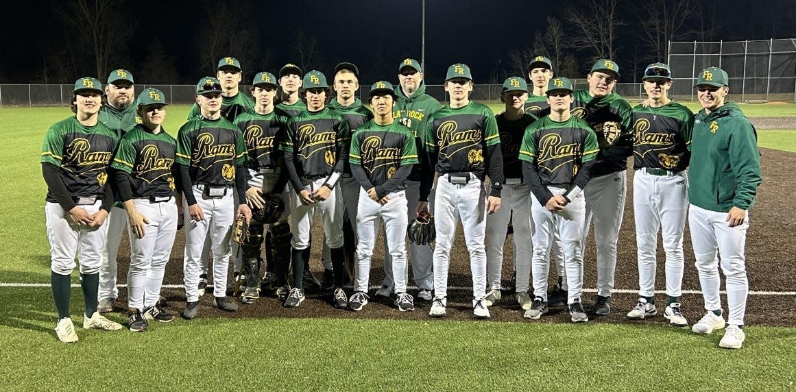 Flat Rock's baseball team poses for a photo following a 4-3 win over Plymouth Thursday, the first victory for new coach Josh Godfrey (right).