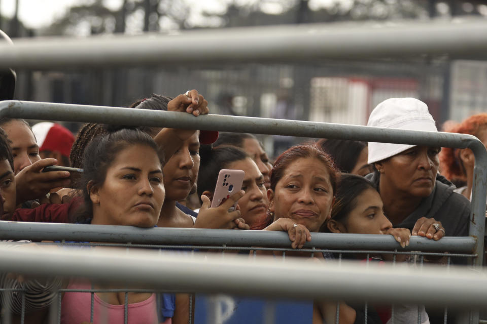 Amigos y familiares de presos esperan noticias de sus seres queridos tras los enfrentamientos con muertos en la Penitenciaría del Litoral de Guayaquil, Ecuador, el martes 25 de julio de 2023. Ecuador anunció el martes un estado de excepción en todo el sistema penitenciario después de una serie de violentos incidentes que incluyeron disparos y explosiones en la cárcel más grande y peligrosa del país. (AP Foto/César Muñoz)