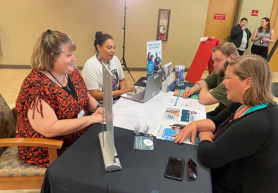 Lisa Thompson, right, speaks with Medicaid navigators at the Falls Community Clinic in Sioux Falls on June 1, 2023.