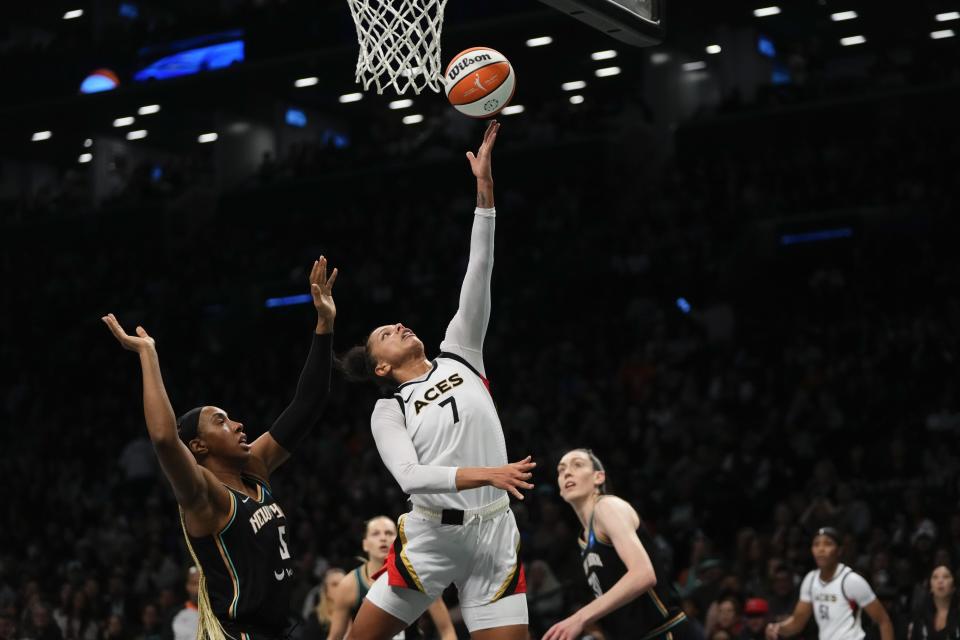 Las Vegas Aces' Alysha Clark (7) drives past New York Liberty's Kayla Thornton (5) and Breanna Stewart during the second half in Game 4 of a WNBA basketball final playoff series Wednesday, Oct. 18, 2023, in New York. The Aces won 70-69. (AP Photo/Frank Franklin II)