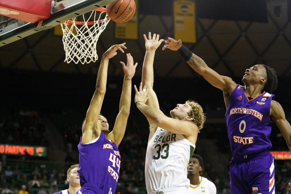Baylor forward Caleb Lohner (33) shoots between Northwestern State defenders Dayne Prim (44) and Demarcus Sharp (0) during the first half of an NCAA college basketball game in Waco, Texas, Tuesday, Dec. 20, 2022. (AP Photo/LM Otero)