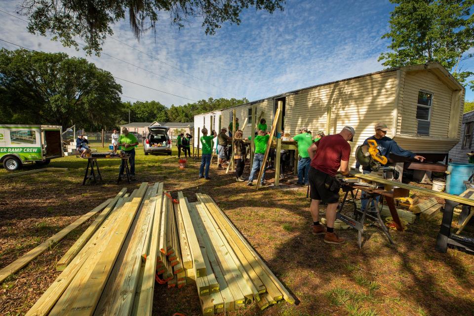Volunteers work to erect a deck and ramp outside a single-wide mobile home in the Kathleen area. Volunteers from Publix and VISTE contributed to the effort, and Habitat for Humanity is supporting the renovation of the home for the Persaud family.
