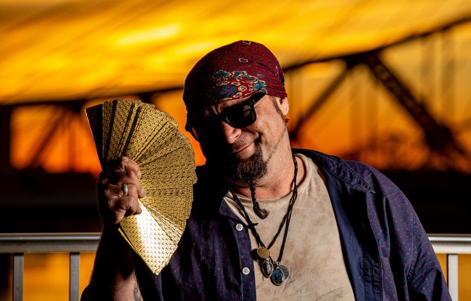 Fortune teller Steven Lafferty fans out his Tarot deck before performing a reading on the Big Four Bridge in Louisville, Ky. Lafferty engages those who stop by with his experience as a mystic and his life as a fortune teller. Nov. 10, 2022