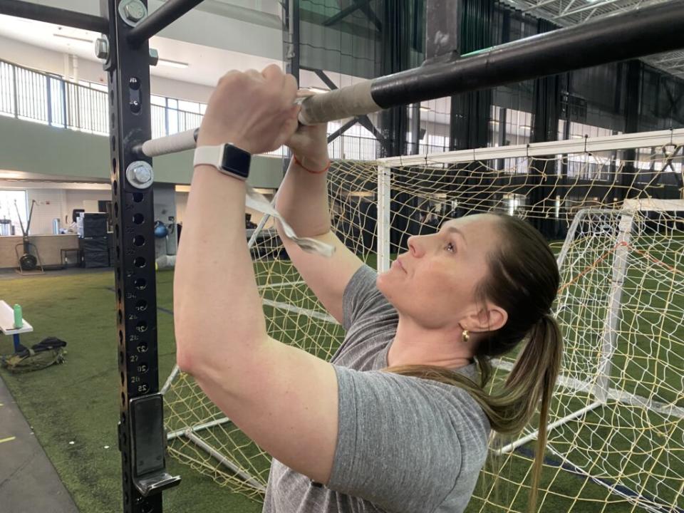 Joanna Livaudais tapes the pull-up bar at the Ben Eielson Air Force Base in preparation for a CrossFit class she teaches. Her three sons will be affected by the closure of the base's junior and senior high school at the end of the year. (Photo by Claire Stremple/Alaska Beacon)