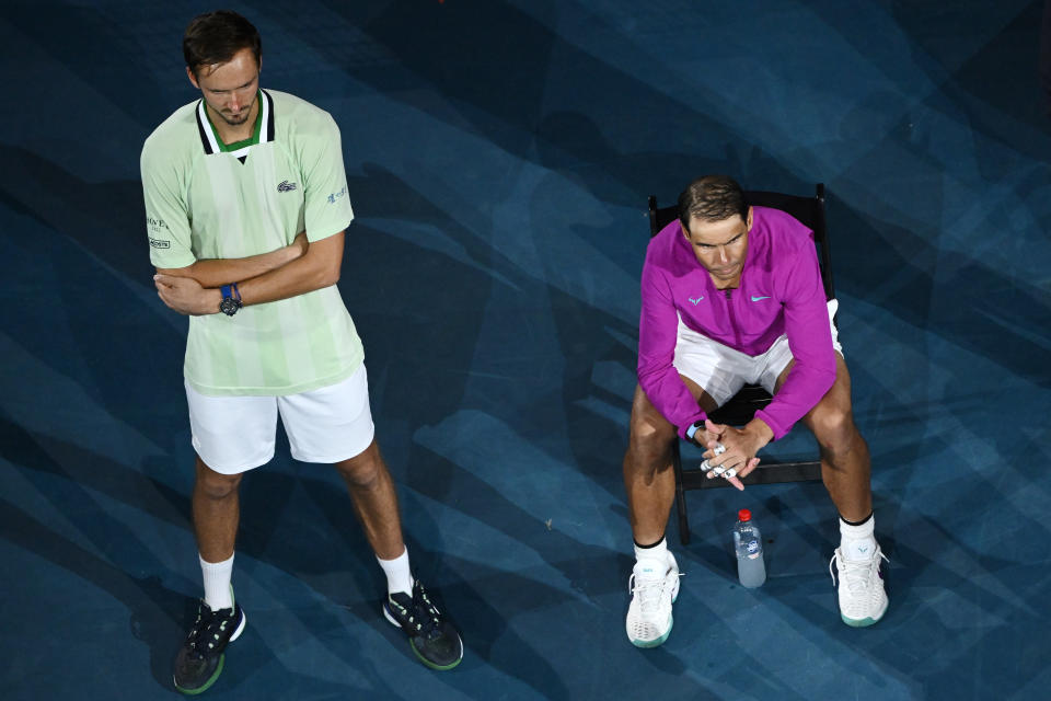 Daniil Medvedev (pictured left) stands as Rafael Nadal (pictured right) sits down during the trophy presentation at the Australiia Open. 