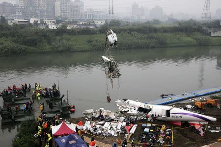 Rescuers lift part of the wreckage of TransAsia Airways plane Flight GE235 after it crash landed into a river, in New Taipei City, February 5, 2015. REUTERS/Stringer
