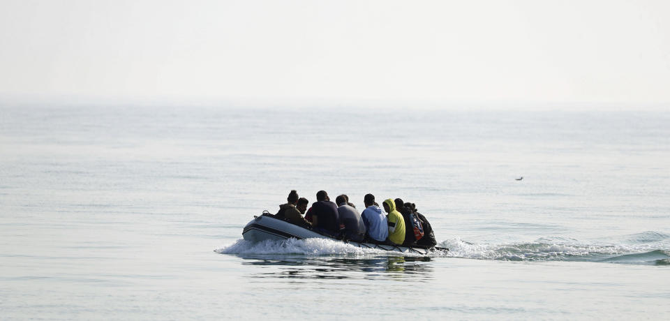 A group of people thought to be migrants arrive in an inflatable boat at Kingsdown beach after crossing the English Channel, near Dover, Kent, England, Monday, Sept. 14, 2020. (Gareth Fuller/PA via AP)