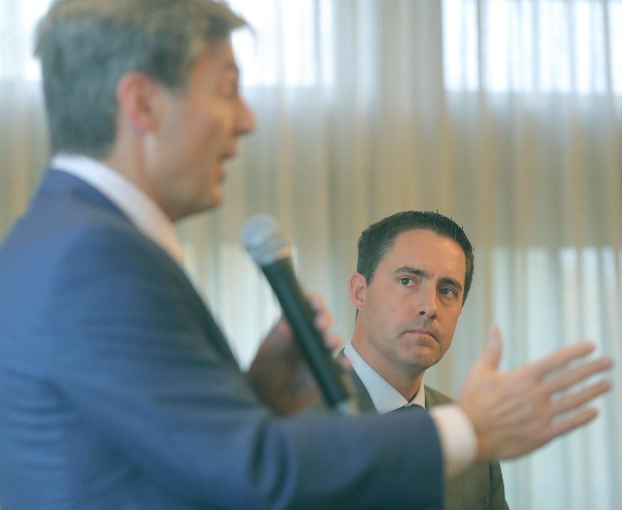 Secretary of State Frank LaRose listens intently as state Sen. Matt Dolan answers a question during a debate among U.S. Senate hopefuls Thursday in Akron.