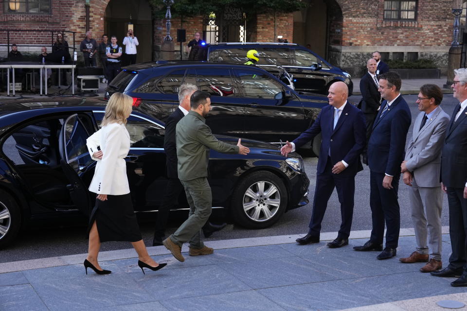 Ukraine's President Volodymyr Zelenskyy and Ukraine's First Lady Olena Zelenska, left, are welcomed by speaker of the Danish Parliament, Soeren Gade in front of the Danish Parliament in Copenhagen, Monday Aug. 21, 2023. (Claus Bech/Ritzau Scanpix via AP)