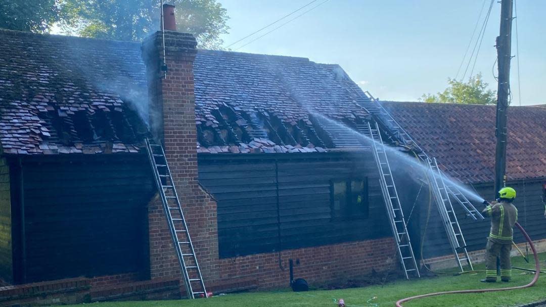 A firefighter sprays water on the property