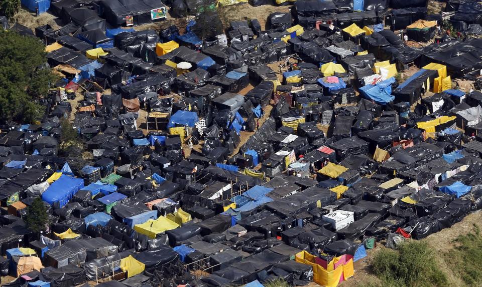 A general view shows shacks belonging to members of the Brazil's Homeless Workers' Movement (MTST) at the "People's World Cup" camp, which houses an estimate of 2,800 families of the movement, in the district of Itaquera near Sao Paulo's World Cup stadium, in Sao Paulo May 8, 2014. For Sao Paulo's most popular soccer team, the World Cup has provided a new home after 100 years playing in rented stadiums. Thousands of neighbors, however, say it has left them homeless. They are squatting on land a couple miles south of Arena Corinthians, a glistening white stadium built for nearly 1 billion reais ($450 million) to host six games during the tournament, including the opening match in less than a month. Picture taken May 8, 2014. To match Feature BRAZIL-WORLDCUP/SAOPAULO REUTERS/Paulo Whitaker (BRAZIL - Tags: SPORT SOCCER WORLD CUP SOCIETY POVERTY)