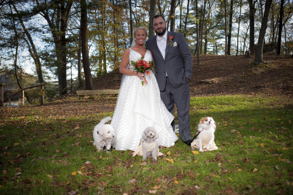 In this Oct. 27, 2017 photo, Kelly Curry and Patrick St. Onge pose with their dogs Charlie, left, Izzy and Zoey for a photo during their wedding day in Haddam, Conn. It's no longer unusual for brides and grooms to include pets in their wedding photos or even in the ceremony. But it can be tough to manage that along with everything else. (Jeffrey Herget/Studio 393 via AP)