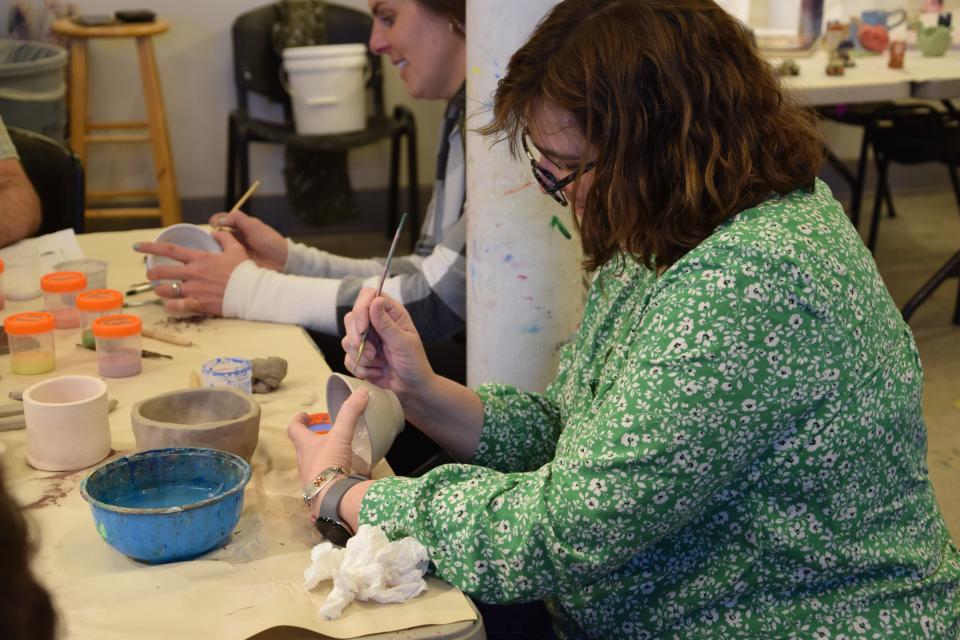 Harbor Light's Katy Hanes paints a small bowl during the pottery workshop on April 15, 2024.